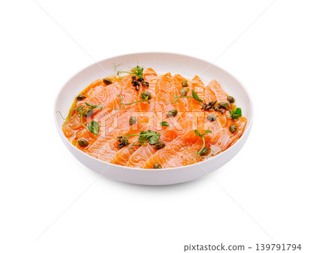 Sliced raw fish served with capers and toppings in a round dish Sliced raw fish served with capers and toppings in a round dish 139791794