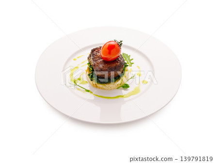 Steak with tomato served on a white plate with green garnish and sauce Steak with tomato served on a white plate with green garnish and sauce 139791819