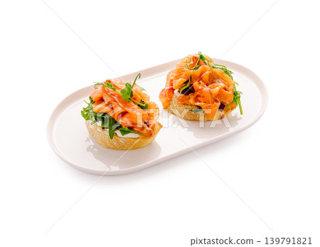 Fresh bread topped with salmon and greens on a simple plate Fresh bread topped with salmon and greens on a simple plate 139791821