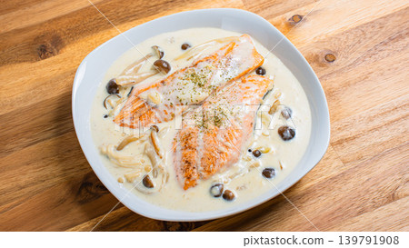 Salmon and mushroom cream stew placed on a wooden table 139791908