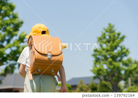 The back view of a girl running with a schoolbag on her back The back view of a girl running with a schoolbag on her back 139792164