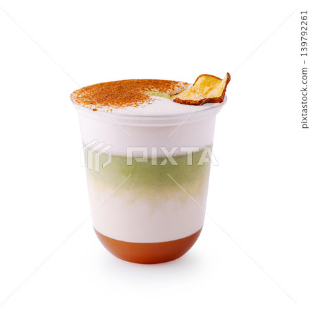 Layered matcha latte with caramel and cinnamon topping 139792261