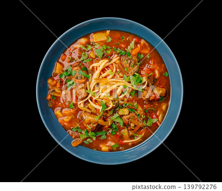 Dish with noodles and meat in a blue bowl on a black background 139792276