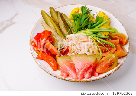 Assorted pickled vegetables platter on white marble background Assorted pickled vegetables platter on white marble background 139792302