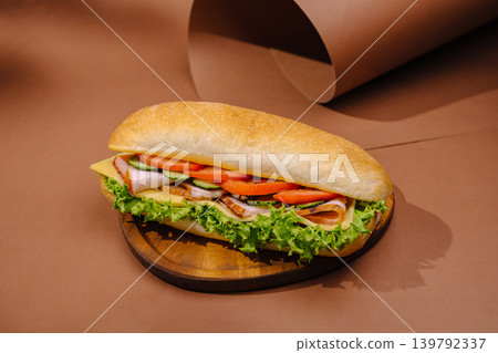 Delicious sandwich filled with fresh toppings on a wooden board Delicious sandwich filled with fresh toppings on a wooden board 139792337