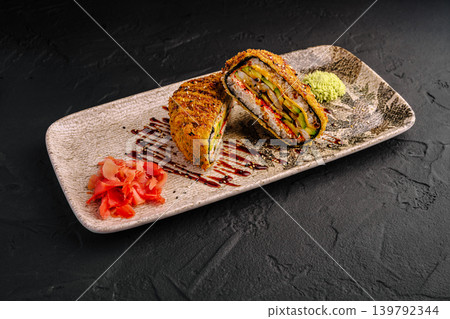 Crispy deep fried sushi burger with shrimp and avocado served with pickled ginger and wasabi on a decorative plate Crispy deep fried sushi burger with shrimp and avocado served with pickled ginger and wasabi on a decorative plate 139792344