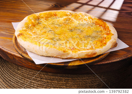 Delicious cheese pizza on wooden table in cozy restaurant setting 139792382