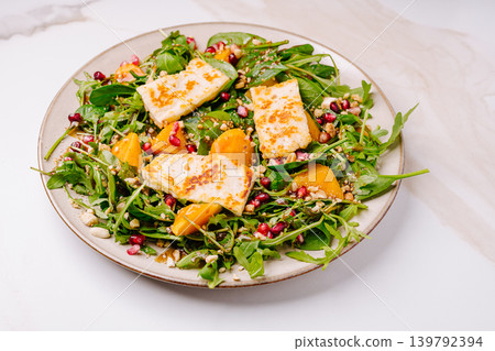Fresh salad with cheese, fruits, and nuts on a plate Fresh salad with cheese, fruits, and nuts on a plate 139792394