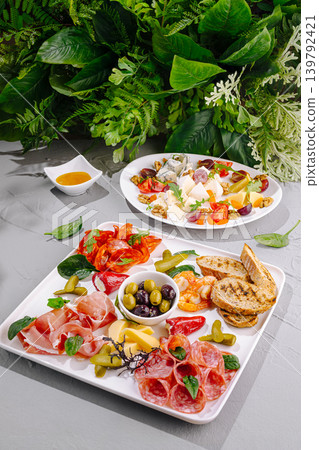Cheese and meat platter served with greens on a dining table 139792421