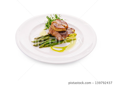 Beef tenderloin steak Rossini with foie gras and asparagus served on a white plate at a restaurant Beef tenderloin steak Rossini with foie gras and asparagus served on a white plate at a restaurant 139792437