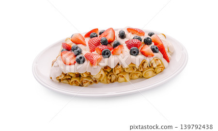 Delicious dessert with crepes, berries, and cream served on a white plate Delicious dessert with crepes, berries, and cream served on a white plate 139792438
