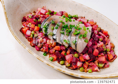 Colorful dish with herring and beet salad served on a white plate Colorful dish with herring and beet salad served on a white plate 139792471