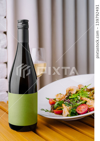 Dinner with wine and salad near a window in an indoor setting Dinner with wine and salad near a window in an indoor setting 139792491