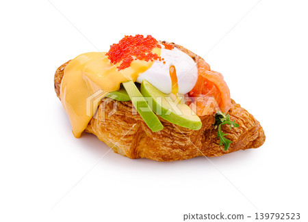 Croissant topped with cheese, avocado, tomato, and sauce on a white background Croissant topped with cheese, avocado, tomato, and sauce on a white background 139792523