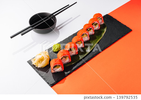 Sushi rolls on a black plate with wasabi and ginger on a white background 139792535