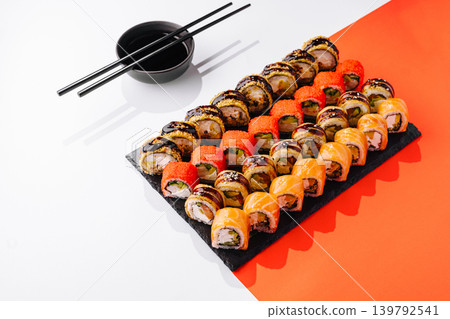 Sushi platter served with chopsticks and sauce on a white table Sushi platter served with chopsticks and sauce on a white table 139792541