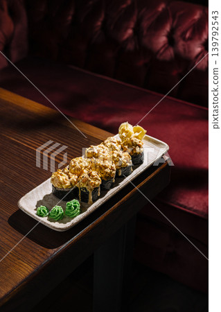 Baked sushi rolls on wooden table in restaurant Baked sushi rolls on wooden table in restaurant 139792543