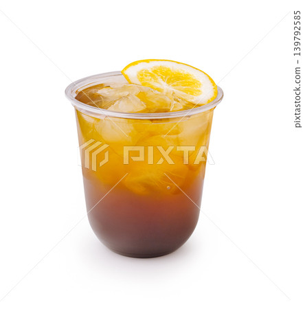 Cold drink with lemon on top in clear cup with ice cubes Cold drink with lemon on top in clear cup with ice cubes 139792585