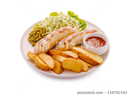 Grilled sausages with potatoes, peas, and salad on a plate during lunch Grilled sausages with potatoes, peas, and salad on a plate during lunch 139792593