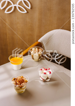 Dessert cups and juice arranged on a table in a bright cafe setting Dessert cups and juice arranged on a table in a bright cafe setting 139792595