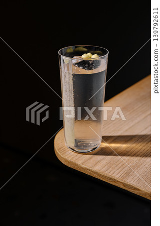 Clear drink with lemon on wooden table in dim light 139792611