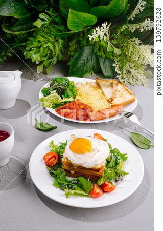 Breakfast plates with eggs, greens, and sausages on table with plants Breakfast plates with eggs, greens, and sausages on table with plants 139792628