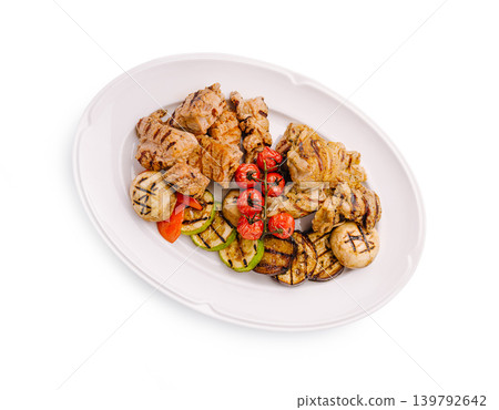 Grilled meat and vegetables served on a white plate at a restaurant Grilled meat and vegetables served on a white plate at a restaurant 139792642