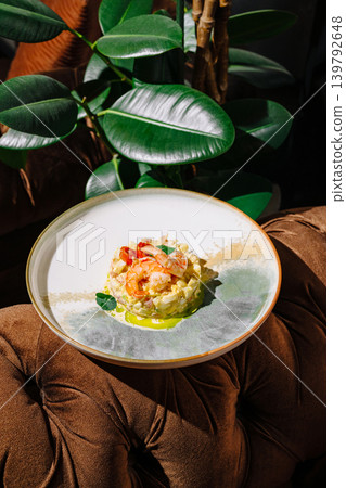 Shrimp tartare salad in elegant restaurant interior with green plants in the background Shrimp tartare salad in elegant restaurant interior with green plants in the background 139792648