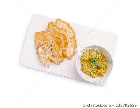Guacamole dip with toasted baguette slices isolated Guacamole dip with toasted baguette slices isolated 139792659