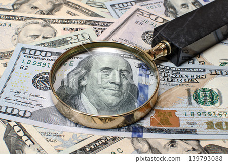 Magnifying glass on dollar banknotes Magnifying glass on dollar banknotes 139793088
