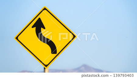An imagined scene with a sign indicating a series of curves ahead. An imagined scene with a sign indicating a series of curves ahead. 139793403