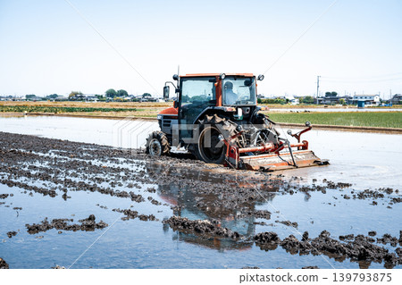 A scene of plowing rice paddies and a tractor in cool colors. A scene of plowing rice paddies and a tractor in cool colors. 139793875