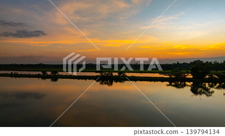 Vibrant Sunset Clouds Reflecting on Calm Water Vibrant Sunset Clouds Reflecting on Calm Water 139794134