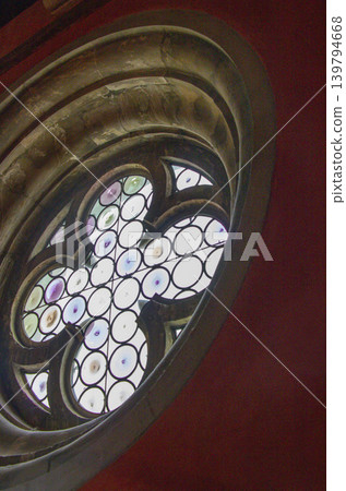 Interior view of a Venetian building: a flower-shaped decorative window with stained glass. Interior view of a Venetian building: a flower-shaped decorative window with stained glass. 139794668
