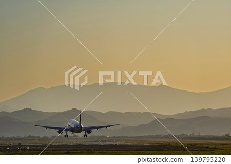 Sendai Airport in the afternoon: A plane landing with the Zao mountain range in the background. Natori City, Miyagi Prefecture. Sendai Airport in the afternoon: A plane landing with the Zao mountain range in the background. Natori City, Miyagi Prefecture. 139795220