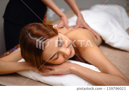Relaxed woman lies on massage table Relaxed woman lies on massage table 139796021