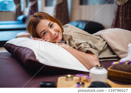 Relaxed woman smiles softly on massage table Relaxed woman smiles softly on massage table 139796027