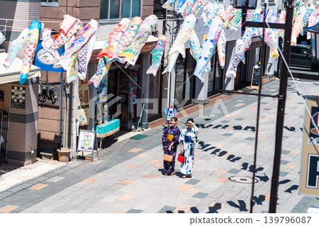 A woman in a yukata (summer kimono) sightseeing in Koedo Kawagoe, with a panoramic view of the traditional storehouse-style townscape. A woman in a yukata (summer kimono) sightseeing in Koedo Kawagoe, with a panoramic view of the traditional storehouse-style townscape. 139796087