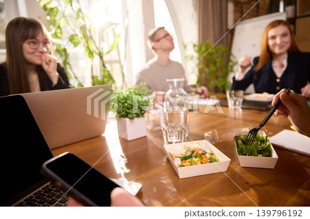 Coworkers having office lunch with salads and ready meals. Coworkers having office lunch with salads and ready meals. 139796192