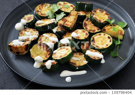 fried zucchini with garlic yogurt sauce on plate fried zucchini with garlic yogurt sauce on plate 139796404