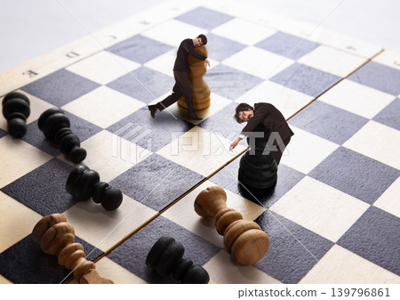 Miniature businessmen leaning on chess pieces during strategic business game. Miniature businessmen leaning on chess pieces during strategic business game. 139796861