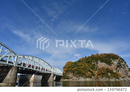 Autumn at the ruins of Unuma Castle and a Meitetsu train crossing the Inuyama Bridge. 139796872