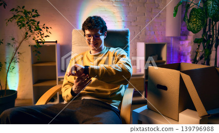 Man using smartwatch at home after unboxing enjoying new technology Man using smartwatch at home after unboxing enjoying new technology 139796988