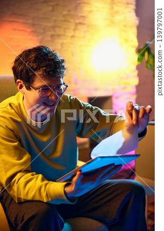 Man removing protective film from tablet screen at home unboxing new device Man removing protective film from tablet screen at home unboxing new device 139797001