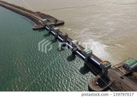 An aerial photograph overlooking the drainage gate of the tidal barrier in the Isahaya Bay reclaimed land area of Nagasaki Prefecture. An aerial photograph overlooking the drainage gate of the tidal barrier in the Isahaya Bay reclaimed land area of Nagasaki Prefecture. 139797017