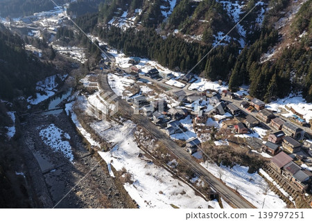 一張冬季航拍照片，從傾斜角度展現了石川縣白山市的一個山村和手取川峽谷。 139797251
