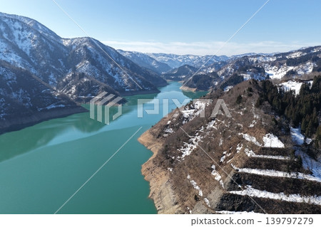 An aerial photograph showing the snow-capped mountains surrounding Lake Tedori in Ishikawa Prefecture, viewed from an oblique angle. An aerial photograph showing the snow-capped mountains surrounding Lake Tedori in Ishikawa Prefecture, viewed from an oblique angle. 139797279