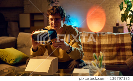 Man unboxing virtual reality headset at home new tech gadget online purchase Man unboxing virtual reality headset at home new tech gadget online purchase 139797385