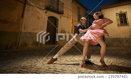 Lindy hop dance couple performing on night street with warm light vintage romance energy Lindy hop dance couple performing on night street with warm light vintage romance energy 139797481