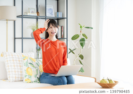 在客廳裡使用電腦的中年婦女 在客廳裡使用電腦的中年婦女 139798485